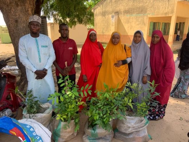 Community members gathered around seedlings during a TRF planting activity